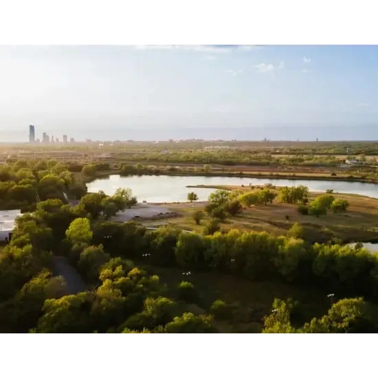 Aerial view of eagle lake park in del city, ok, skyline and river.