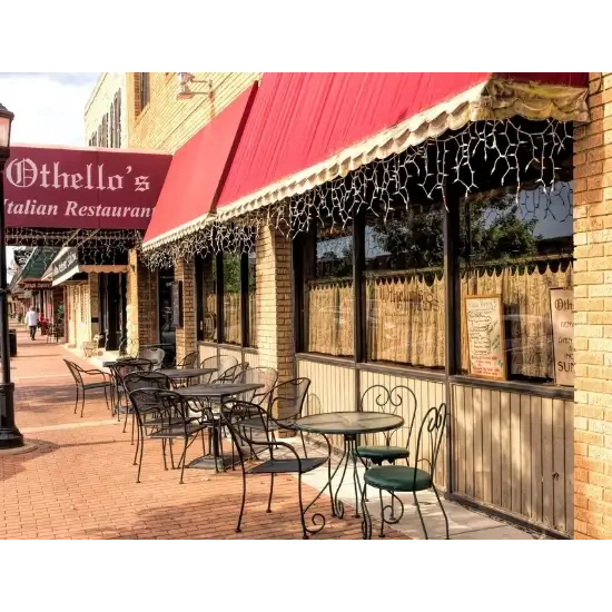Outdoor seating at Italian restaurant, Othello's in edmond, ok, with red awning.