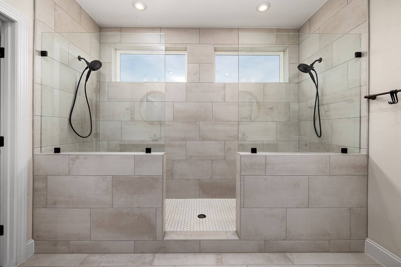 Modern dual stone accent shower with glass panels. Image by curtis adams