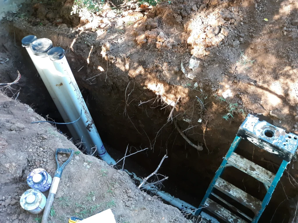 Underground pipe installation in progress with tools nearby.